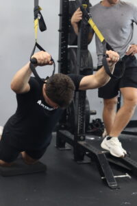 Athlete working on building core strength using TRX training.